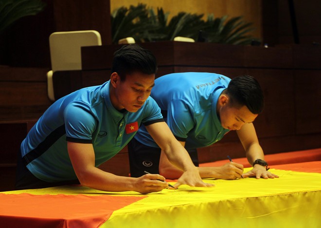 Các cầu thủ U23 Việt Nam ký tên lên lá đại kỳ do Chủ tịch Quốc hội mang về từ Lũng Cú ảnh 3