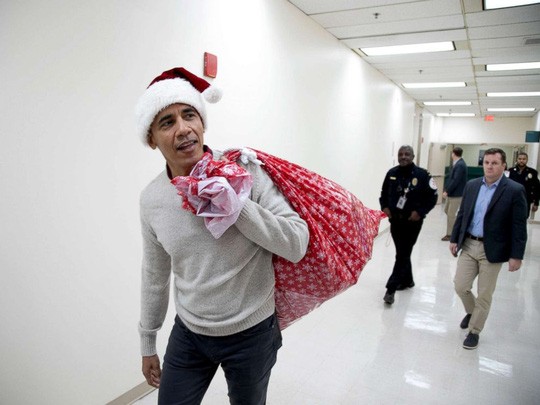 'Ông già Noel' Obama đội mũ đỏ, khệ nệ vác túi quà to ảnh 1