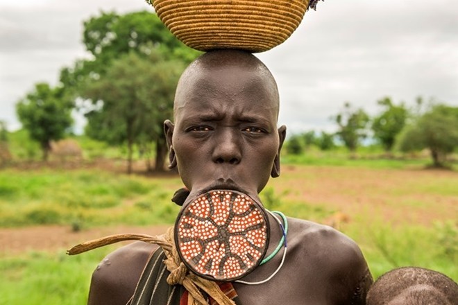 Phong tục lồng đĩa vào môi của người Surma ở Ethiopia biểu tượng cho điều gì?