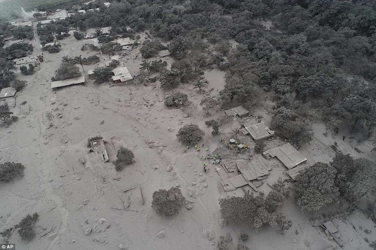 Volcanic ash blankets homes and trees near the Volcan de Fuego, or "Volcano of Fire," where rescue workers gather in the El Rodeo hamlet of Escuintla