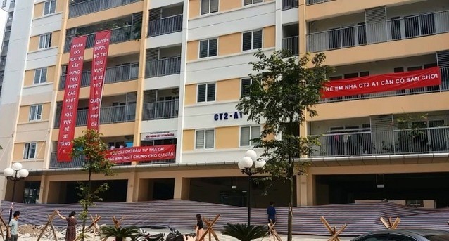 Cư dân căng băng rôn phản đối HUD sửa thiết kế lấn chiếm bãi xe, sân chơi ảnh 1