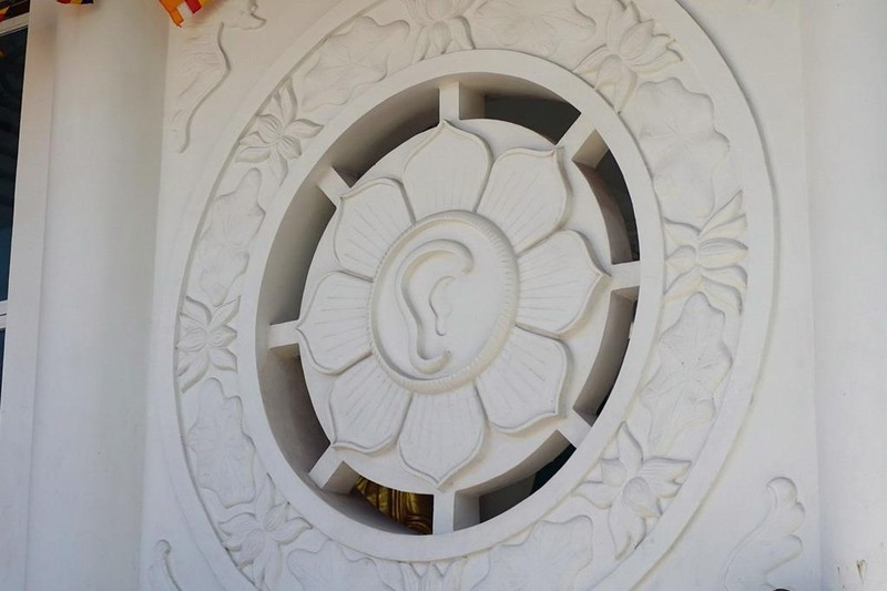 Hai bên cửa chính có hai ô cửa hình hoa sen mang một mắt và một tai nằm trong bánh xe Phật pháp, mang hàm ý “Nhất tâm nghe, thấy, ngay đấy thấy Phật”.