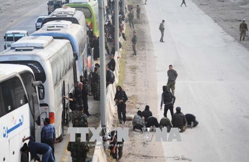 Xe buýt chở các tay súng nổi dậy cùng gia đình rời khỏi thành phố Harasta, ngoại ô Đông Ghouta ngày 22/3/2018. Ảnh tư liệu: THX/TTXVN