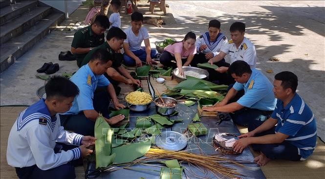 Người dân và cán bộ, chiến sĩ thị trấn Trường Sa quây quần gói bánh chưng chuẩn bị đón Tết Kỷ Hợi. Ảnh: Hoàng Hùng/TTXVN