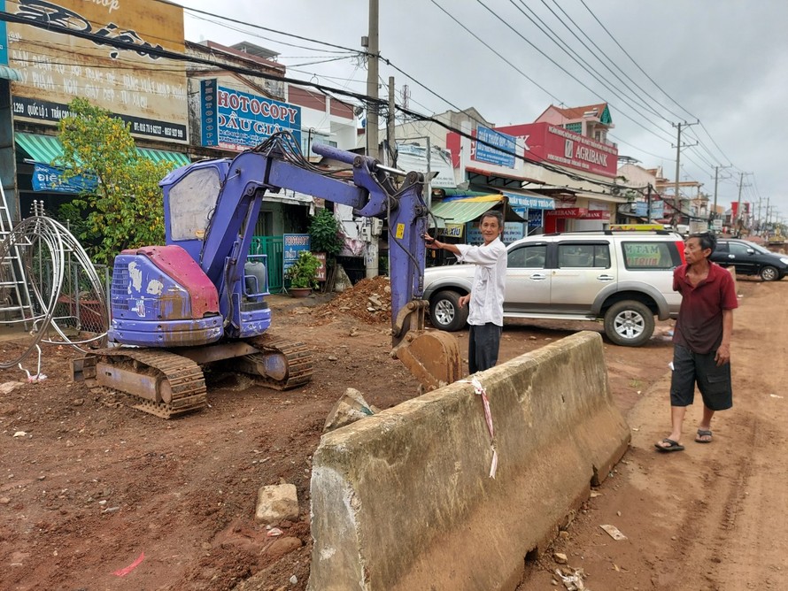 Xe múc nằm im, đất đai bị đào xới lên rồi để nguyên hiện trạng trước nhà dân. Ảnh: Xuân Thời