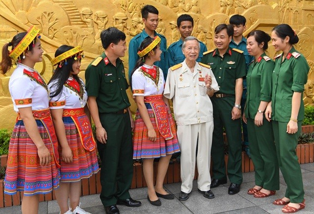 Anh hùng LLVT nhân dân La Văn Cầu (thứ tư từ phải sang) kể chuyện truyền thống với các bạn trẻ. (Ảnh: QĐND).