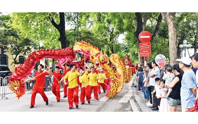 Người dân và khách du lịch tham quan, thưởng lãm các hoạt động văn hóa tại khu vực phố đi bộ chung quanh hồ Hoàn Kiếm. 