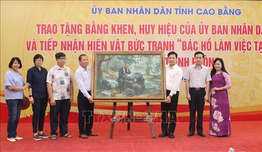 Đại diện gia đình họa sĩ Trịnh Phòng trao tặng bức tranh cho tỉnh Cao Bằng. 