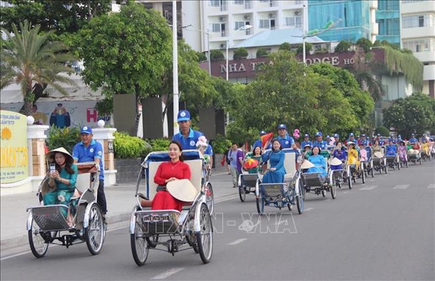 Đoàn xe xích lô chở chị em phụ nữ mặc ào dài qua tuyến phố Trần Phú, Nha Trang. 