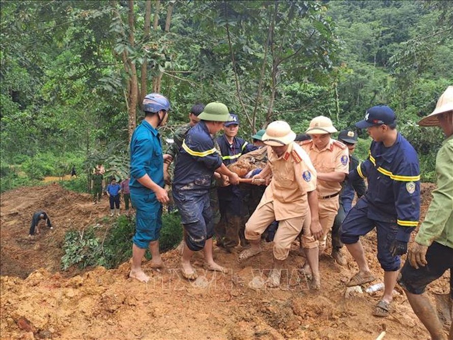 Các lực lượng tìm kiếm đưa thi thể nạn nhân bị vùi lấp ra khỏi khu vực sạt lở. 