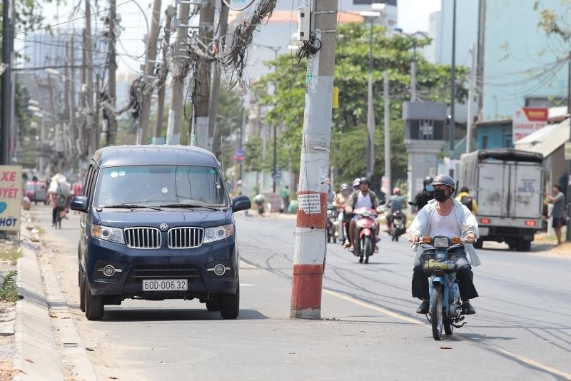 Dãy cột điện nằm dưới lòng đường gây mất an toàn giao thông. Ảnh: A.H.