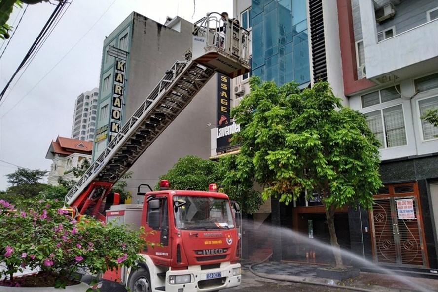 Lực lượng chức năng đang dập lửa và cứu người mắc kẹt bên trong. (Ảnh: Lao Động)