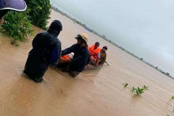 Lực lượng chức năng đưa người dân bị mắc kẹt vào bờ an toàn. (Nguồn: sggp.org.vn)