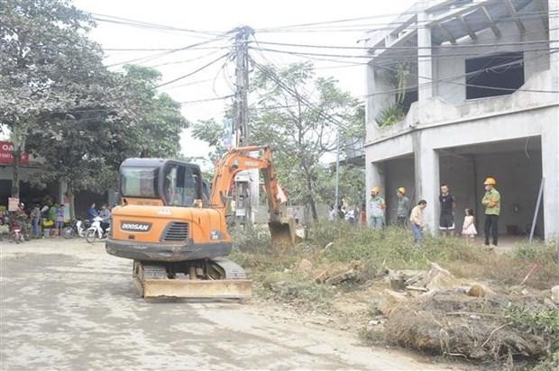 Huyện Ba Vì (Hà Nội) huy động phương tiện cơ giới thực hiện cưỡng chế tháo dỡ, cây, tường rào...trong phạm vi giải phóng mặt bằng. (Ảnh Mạnh Khánh/TTXVN)