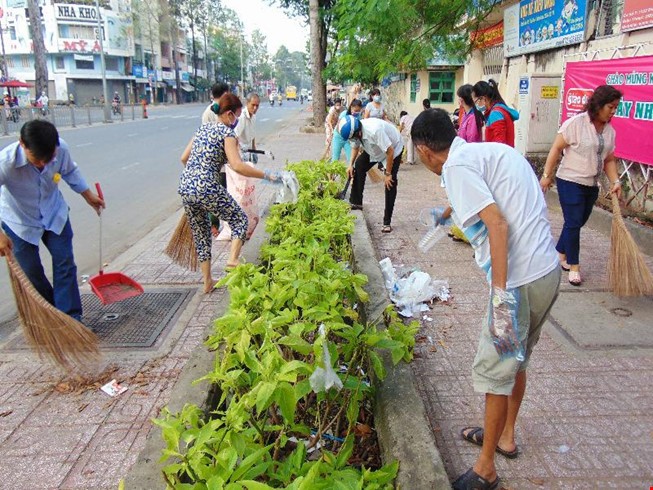 Bà con phường 12, quận 11 (TP.HCM) dọn dẹp vật thải đọng nước để lăng quăng không có điều kiện phát sinh. (Ảnh: Trần Ngọc - chụp sáng 20-11)