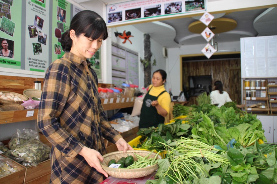 Emiko đang kiểm tra rau trong cửa hàng nông sản sạch của mình