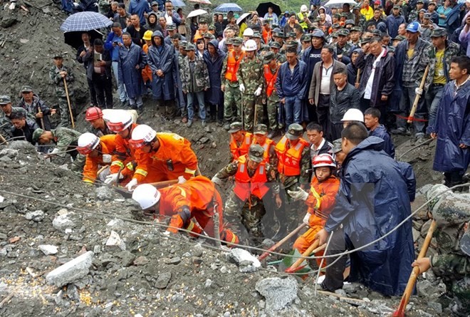 Nhân viên cứu hộ nỗ lực tìm kiếm người mất tích trong vụ lở đất. (Nguồn: EPA/TTXVN)