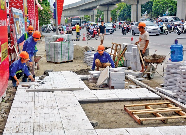 Thi công lát đá tự nhiên cho vỉa hè trên đường Nguyễn Trãi, quận Thanh Xuân, Hà Nội - Ảnh: Lê Tươi