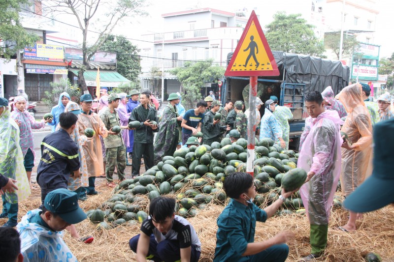 Lực lượng bộ đội, công an, dân quân cùng người dân hỗ trợ chủ hàng xếp dưa