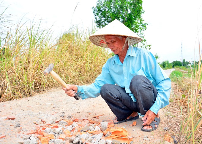 Hơn chục năm nay ông Toàn vẫn lặng lẽ vá những đoạn đường hư hỏng. (Ảnh: NQ).