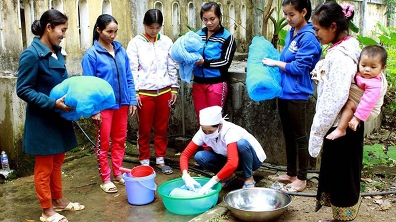 Cán bộ y tế hướng dẫn người dân ngâm, tẩm hóa chất vào màn để phòng, chống bệnh sốt rét. (Ảnh minh họa)