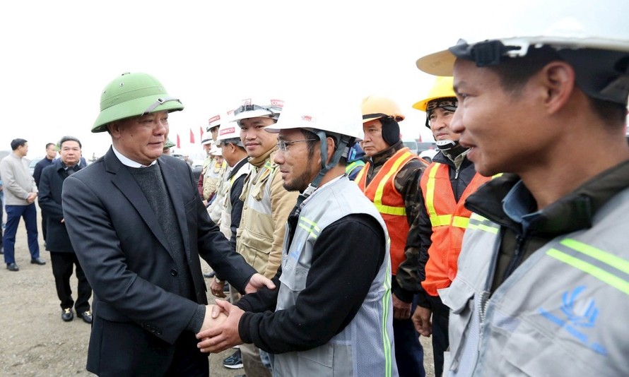 Bí thư Thành ủy Hà Nội Đinh Tiến Dũng thăm hỏi, chúc Tết và tặng quà công nhân đang làm nhiệm vụ trên công trường xây dựng đường Vành đai 4 - Vùng Thủ đô Hà Nội tại xã Thuận Thành (tỉnh Bắc Ninh). (Ảnh Viết Thành)