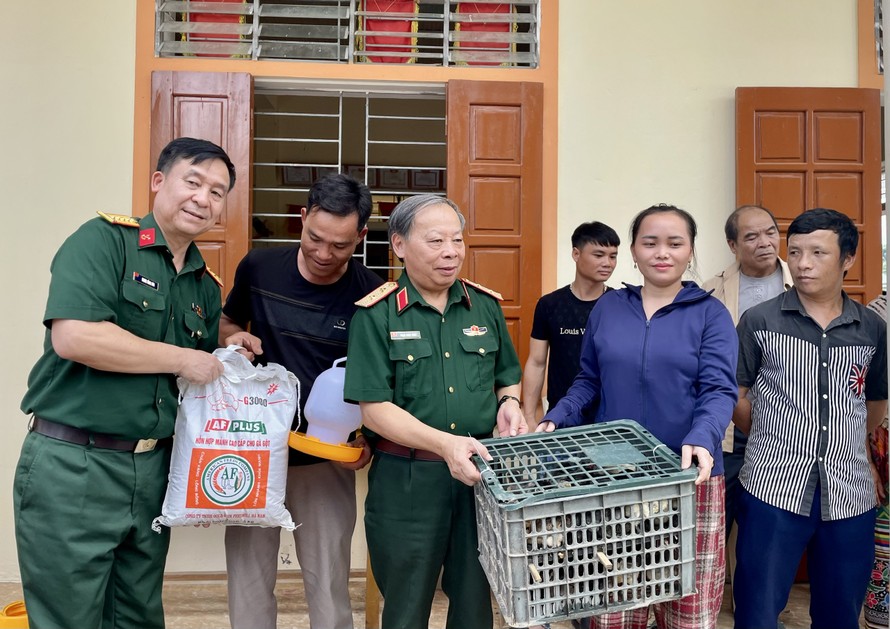 Đoàn công tác tặng gà và thức ăn gia cầm cho các nạn nhân bom mìn tại xã Chiêu Lưu, huyện Kỳ Sơn.