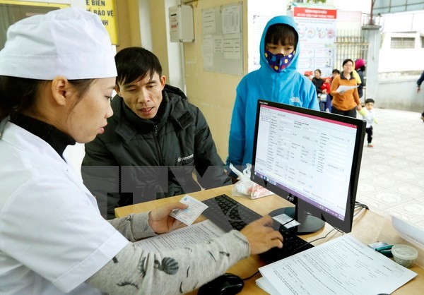 Nhân viên y tế làm thủ tục khám chữa bệnh cho người dân. (Ảnh: TTXVN/Vietnam+)