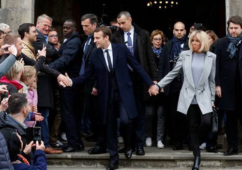 Emmanuel Macron và vợ Brigitte Trogneux rời khỏi một điểm bỏ phiếu vòng một bầu cử hồi tháng 4. Ảnh: Reuters 