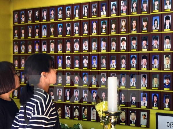 Du khách cầu nguyện trước di ảnh các nạn nhân trong vụ chìm phà Sewol ở Seoul ngày 25/5. (Nguồn: AFP/TTXVN)