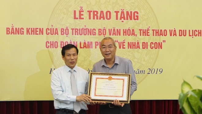 Bộ trưởng Bộ Văn hóa - Thể thao - Du lịch Nguyễn Ngọc Thiện tặng bằng khen cho đạo diễn Nguyễn Danh Dũng ngày 21/8. Ảnh: Thanh Niên