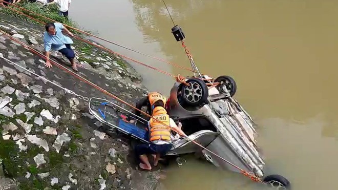 Lực lượng chức năng trục vớt chiếc xe taxi rơi xuống sông Cầu Chày. Ảnh: Thanh Niên