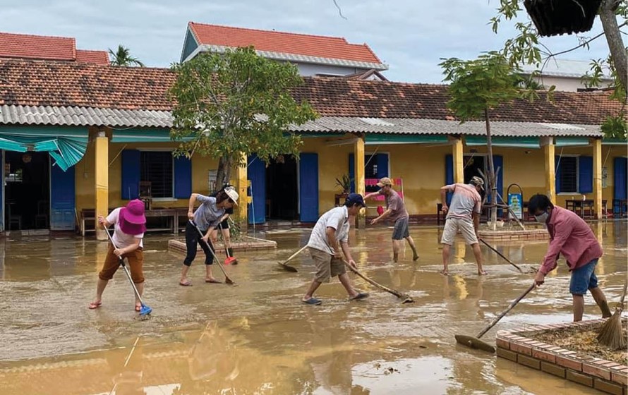 Giáo viên dọn vệ sinh trường học sau lũ. Ảnh: Báo Thừa Thiên-Huế