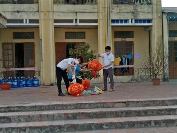 Phụ huynh tất bật trang trí sân trường khu cách ly tại trường tiểu học Lai Cách (huyện Cẩm Giàng) với mong muốn phần nào mang đến không gian Tết vào khu cách ly, đem lại niềm vui cho trẻ. Ảnh: TTXVN