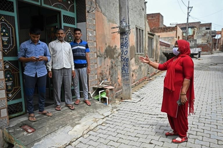 Một nhân viên y tế đi tuyên truyền cho người dân tại làng Kalwa (bang Haryana). Ảnh: AFP