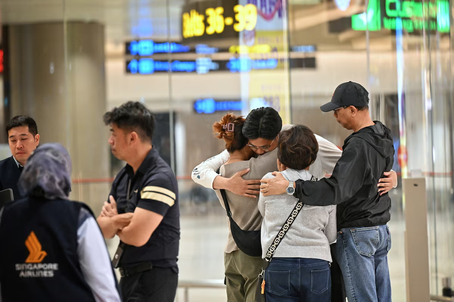 Nam hành khách đoàn tụ với gia đình tại sân bay Changi. Ảnh: Reuters