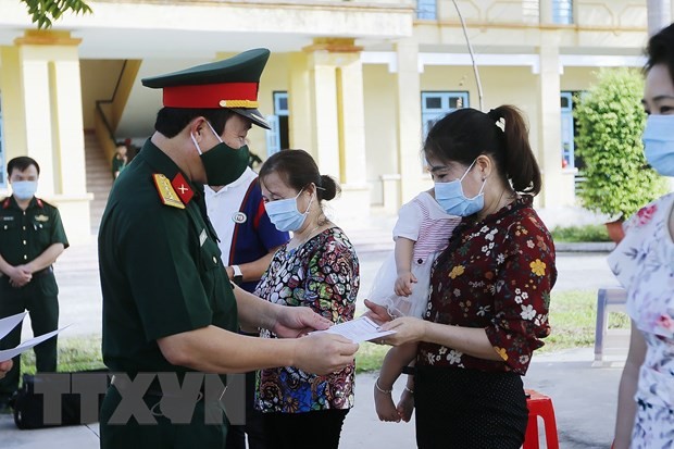 Trao giấy chứng nhận hoàn thành thời gian cách ly theo dõi COVID-19 cho các công dân tại tỉnh Hoà Bình. (Ảnh: Trọng Đạt/TTXVN)