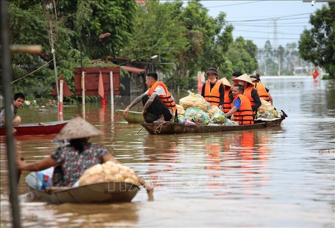 Người dân vận chuyển nhu yếu phẩm vào hỗ trợ người dân trong vùng lũ xã Trí Yên, huyện Yên Dũng (Bắc Giang).