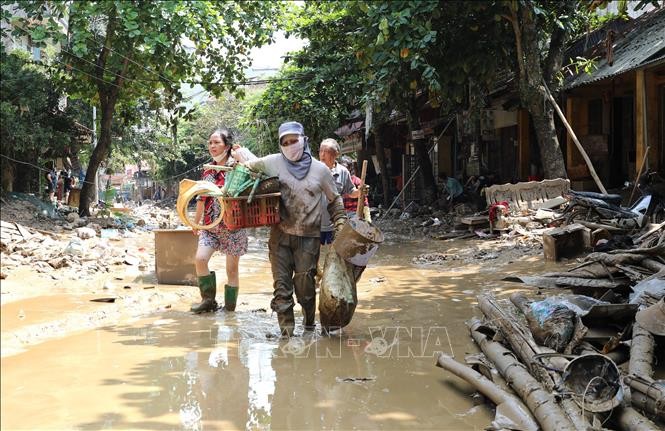 Người dân lội bùn khi di chuyển trên 2 tuyến phố Thanh Niên và Trần Hưng Đạo (thành phố Yên Bái, tỉnh Yên Bái).