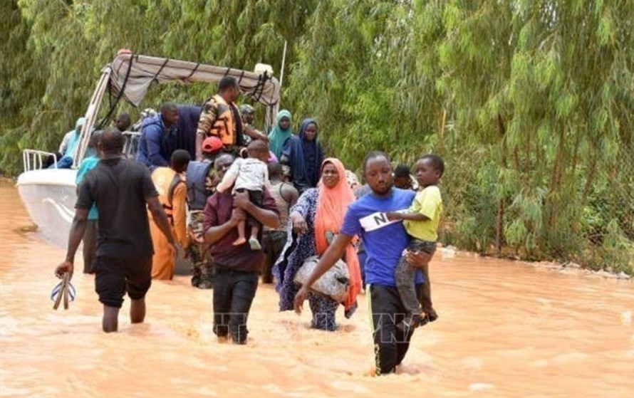 Người dân sơ tán khỏi vùng ngập lụt sau những trận mưa lớn tại Niamey, Niger. Ảnh: Getty Images/TTXVN