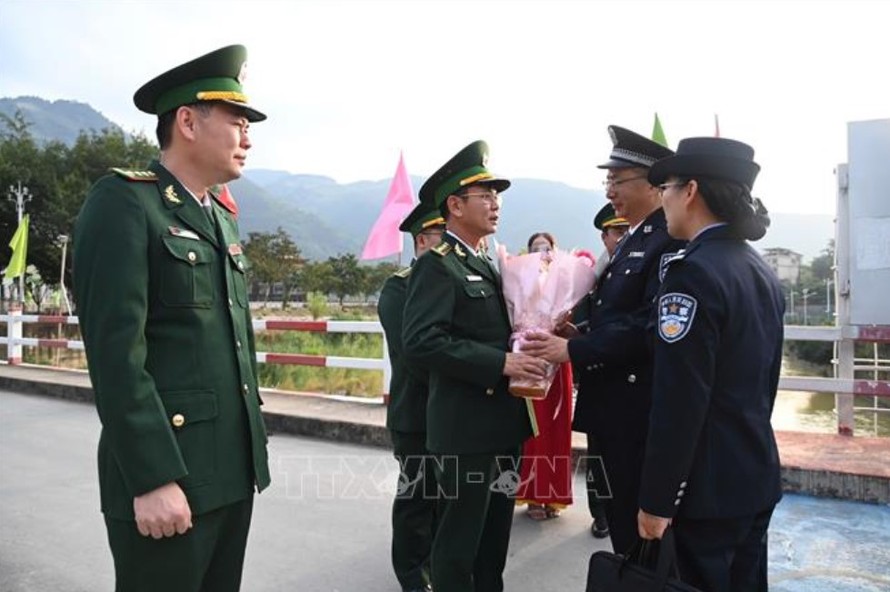 Đoàn đại biểu Bộ đội Biên phòng tỉnh Lai Châu tặng hoa Chi đội Quản lý biên giới Hồng Hà, tỉnh Vân Nam tại vạch phân địch cầu Hữu nghị Việt - Trung. Ảnh: TTXVN phát