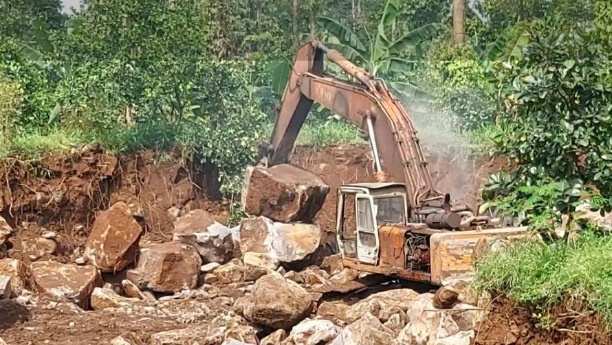 Xe đào đang khai thác đá mồ côi trong rừng phòng hộ.