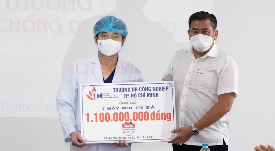 TS. Phan Hồng Hải – Hiệu trưởng Trường Đại học Công nghiệp TP.HCM (phải) trao bảng tượng trưng ủng hộ máy xét nghiệm RT-PCT cho bệnh viện An Bình.