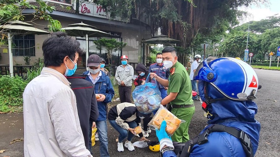 Lực lượng Công an hỗ trợ phân phối thức ăn và nước uống cho người dân trên hành trình về quê nhà.