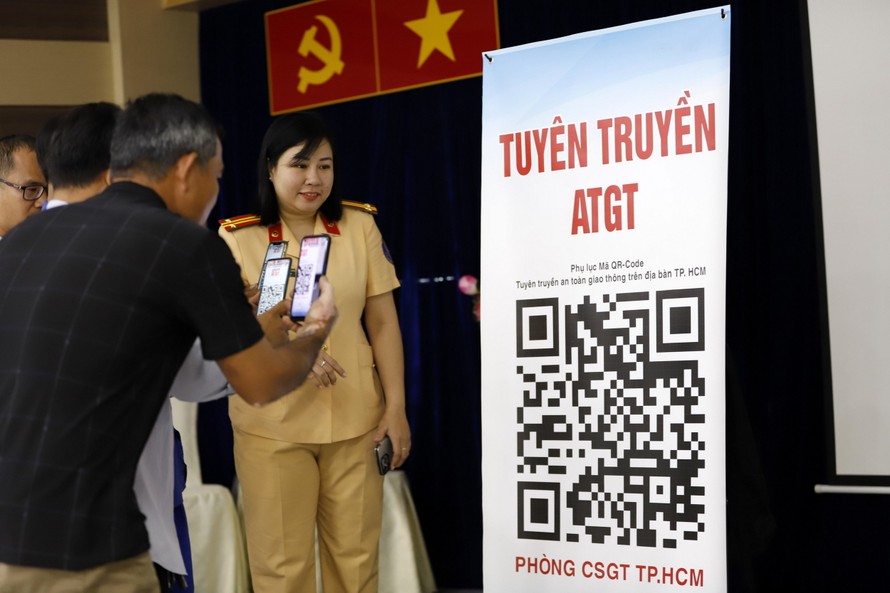 Cán bộ CSGT hướng dẫn tài xế quét mã QR Code để cập nhật thông tin tuyên truyền.