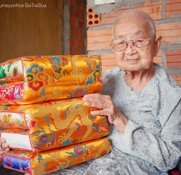 'Mệ'' Công Tôn Nữ Trí Huệ cầm trên tay sản phẩm gối tựa cung đình Huế.