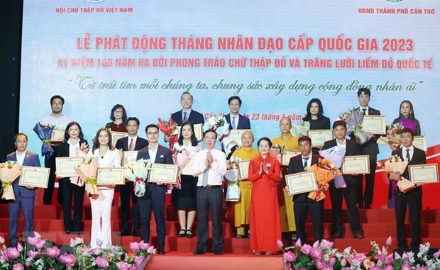 Chủ tịch nước Võ Văn Thưởng, Chủ tịch danh dự Hội Chữ thập Đỏ Việt Nam và bà Bùi Thị Hòa, Chủ tịch Hội Chữ thập Đỏ Việt Nam tặng hoa và trao bảng Ghi nhận tấm lòng vàng nhân đạo. Ảnh: Thống Nhất/TTXVN.