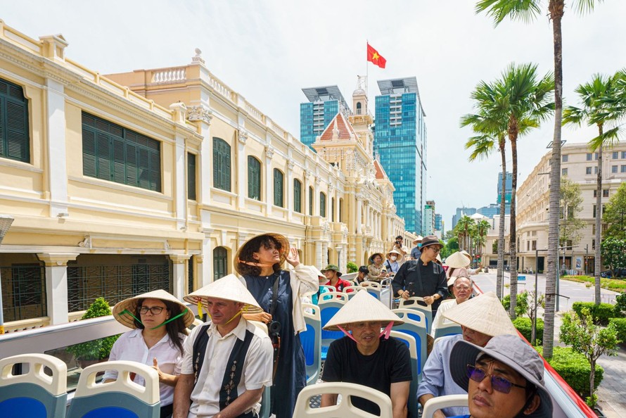 Du khách tham quan trụ sở UBND - HĐND TP Hồ Chí Minh bằng xe buýt hai tầng.