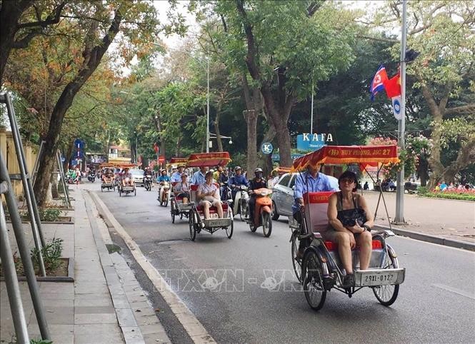 Ngồi xích lô tham quan, ngắm cảnh xung quanh hồ Gươm được du khách nước ngoài rất ưa thích khi đến Hà Nội. Ảnh: TTXVN.