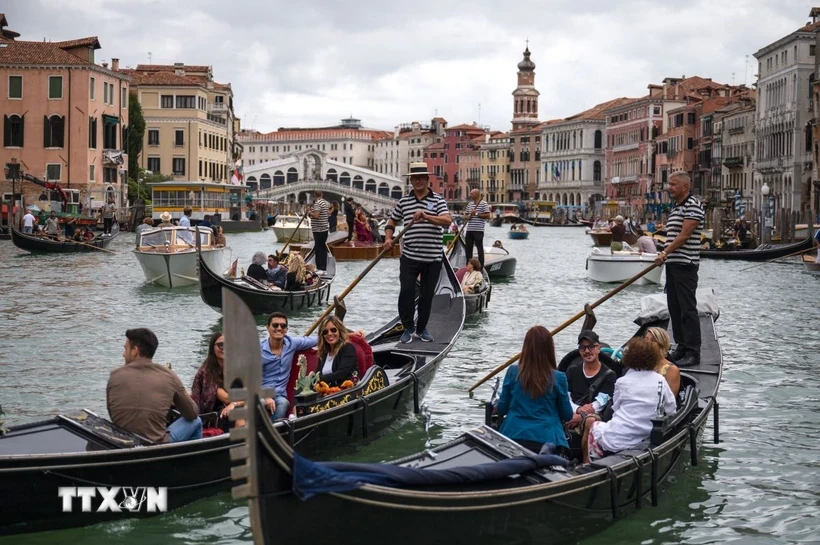 Du khách đi thuyền gondola tại Venice, Italy. Ảnh: AFP/TTXVN.